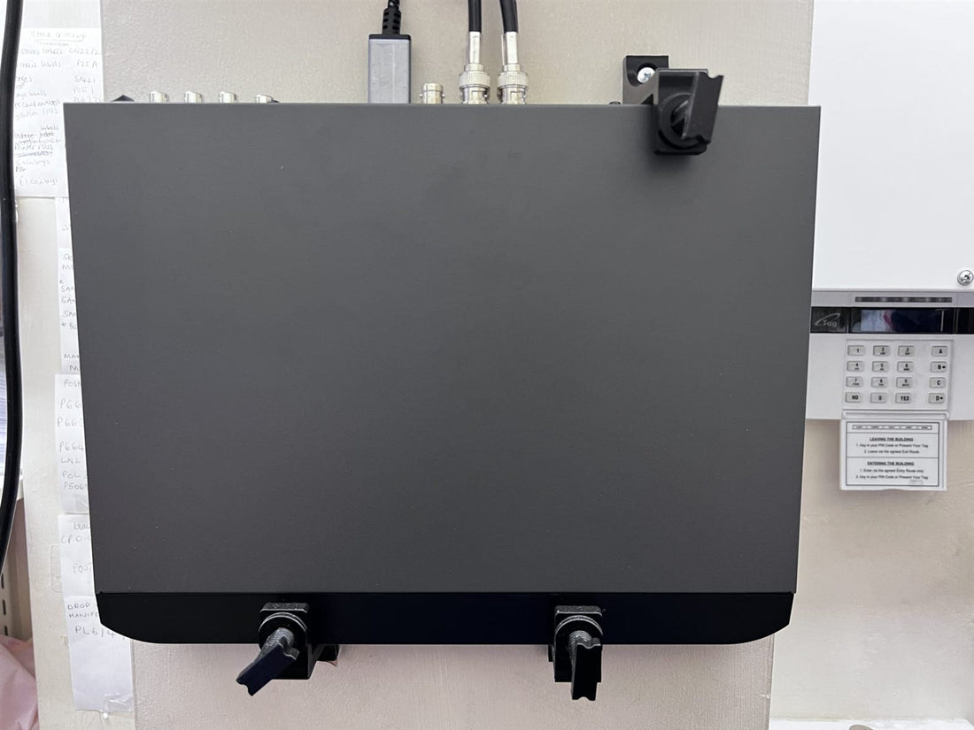 CCTV recorder mounted upright on a wall with three adjustable brackets, two under the bottom edge and one over the top