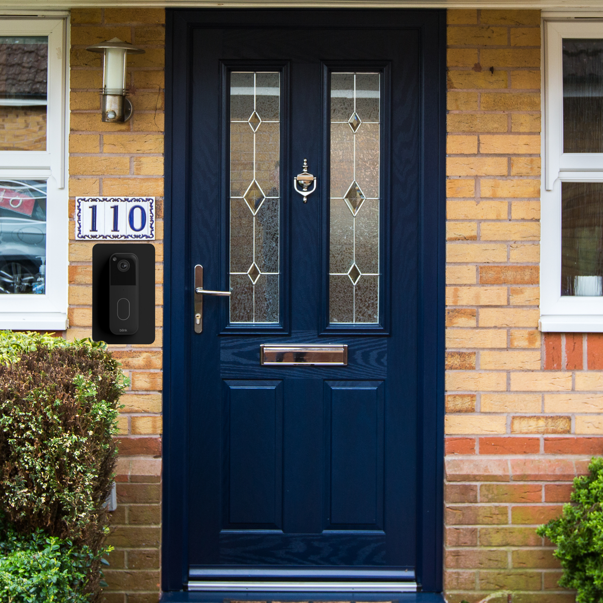 Blink doorbell on the wall plate beside a blue front door
