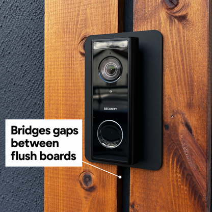 Black wall plate bridging the gap between two flush timber boards behind a Eufy doorbell