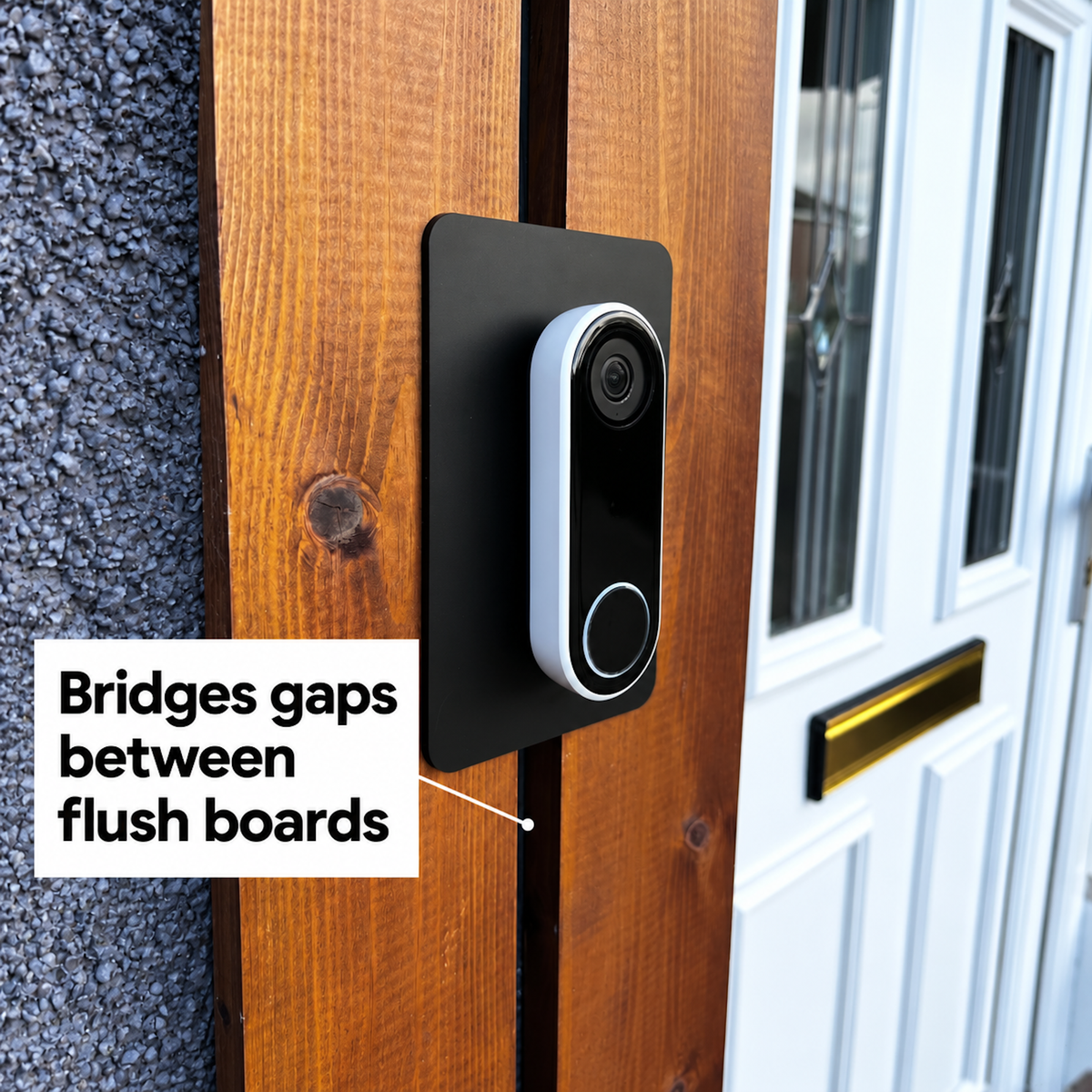 Black wall plate bridging the gap between two flush timber boards behind a Google Nest doorbell
